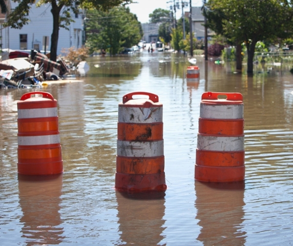 flood roadway with orange traffic drums